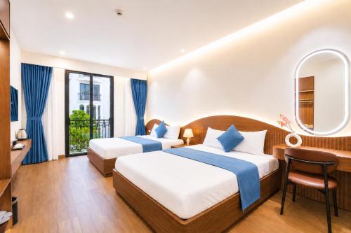 two beds in a hotel room with a balcony at Sunset Samson Hotel in Sầm Sơn