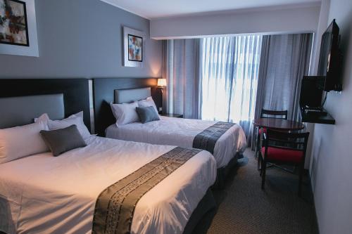 Un pat sau paturi într-o cameră la Apart Hotel Petit Palace Suites