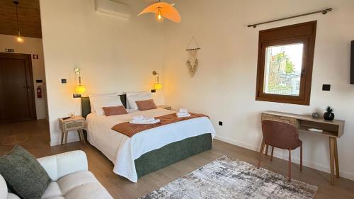 a bedroom with a bed and a couch at River Breeze Douro - Casa Touriga in Marmelal