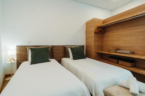 two twin beds in a room with wooden walls at Estação do Parque in Santa Maria Da Feira