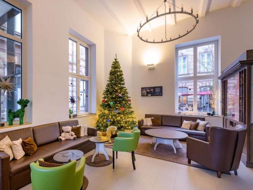 a living room with a christmas tree and a couch at Ibis Styles Trier in Trier