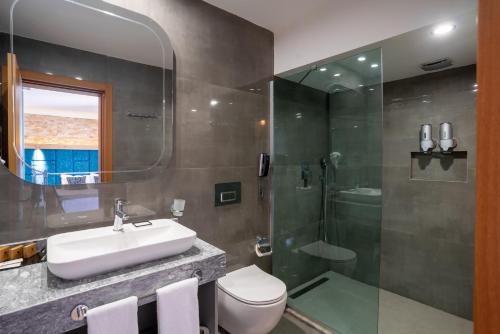 a bathroom with a sink and a shower and a toilet at Assos Dove Hotel Resort & SPA in Behramkale