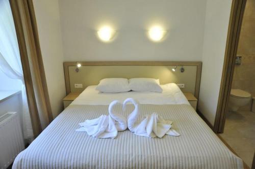 two swans towels on a bed in a bedroom at Apartamenty Watra in Rabka-Zdrój