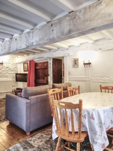 a living room with a table and a couch at Longhouse - Y Beudy in Rhayader