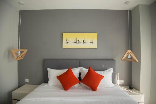 a bedroom with a bed with two orange pillows at 85 SOHO Premium Residences in Yangon