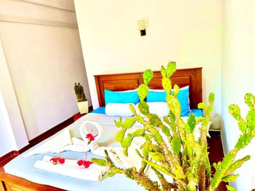 a bedroom with a bed with towels and a plant at Ceylan Crest in Ella