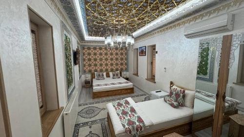 a living room with two beds and a chandelier at SILVER Inn in Bukhara