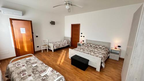 a hotel room with two beds and a chair at Locanda dei Sapori in Marozzo