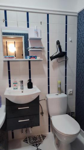 a bathroom with a white toilet and a sink at Blue House 2 in Warsaw