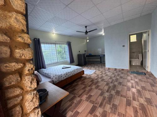 a bedroom with a bed in a room with a brick wall at Tranquility Apartment in Pokhara