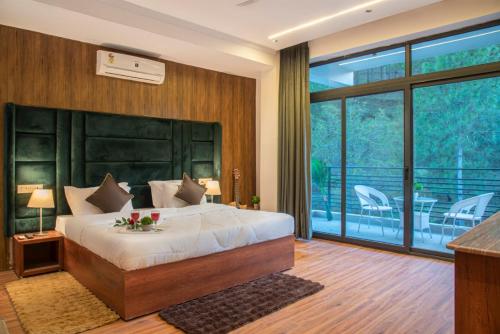 a bedroom with a large bed and a balcony at The Royal Apartments Manor I Roof Top Restaurant I Self Cooking Available I Lift I 7o1827o7o3 in Kasauli