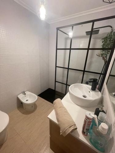 a white bathroom with a sink and a toilet at Playa y Geoda, escapada perfecta in Pilar de Jaravía