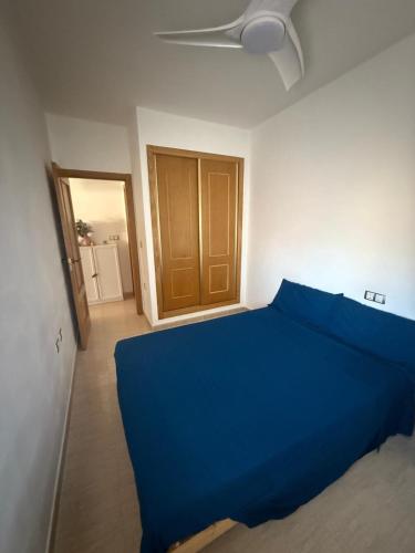 a blue bed in a room with a door at Playa y Geoda, escapada perfecta in Pilar de Jaravía