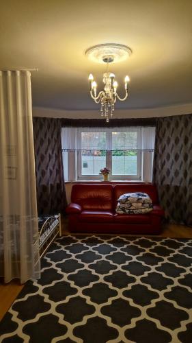 a living room with a red couch and a window at Blue House 2 in Warsaw