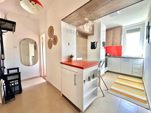 a kitchen with white cabinets and a red counter top at Casa Viola in Balatonfüred