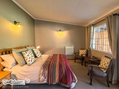 a bedroom with a bed and a chair and a window at Suikerbosch Room 1 and Room 2 in Dullstroom