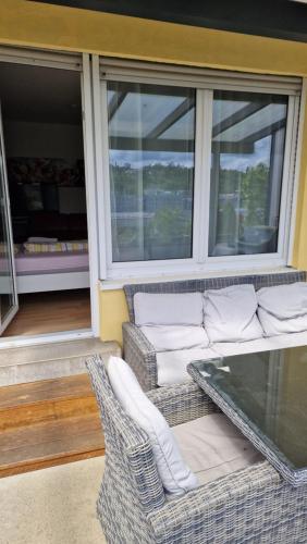 a screened in porch with a couch and chairs at Rooms & Apartments Schwäbisch Gmünd in Schwäbisch Gmünd