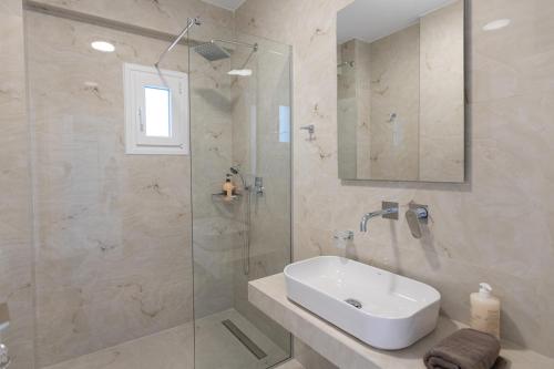 a bathroom with a sink and a glass shower at Victoria Residence in Thessaloniki