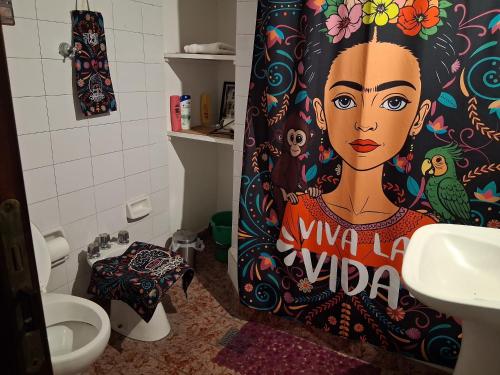 a bathroom with a shower curtain with a painting of a woman at FRIDA APARTMENT remis gratis a Ezeiza in Ezeiza