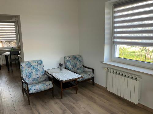 a room with two chairs and a table and a window at Apartament z pianinem in Grajewo