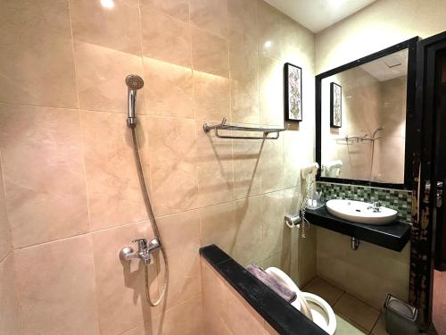 a bathroom with a shower and a sink at Hotel De Green Lampung in Lampung