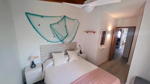 a bedroom with a bed with a net on the wall at Paradise COSTA ARENAL in Es Mercadal