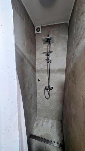 a shower in a bathroom with a stone wall at Paradise COSTA ARENAL in Es Mercadal