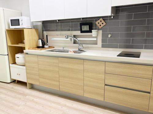 a kitchen with a sink and a refrigerator at 깨비하우스201 in Wŏlsan