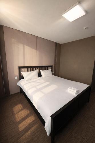 a bedroom with a large bed with white sheets and pillows at Sats hotel in Ulaanbaatar
