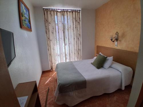 a bedroom with a bed and a large window at Pension Segura in Murcia
