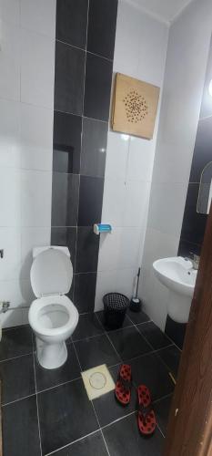 a bathroom with a toilet and a sink with slippers at الاردن - جرش in Jerash