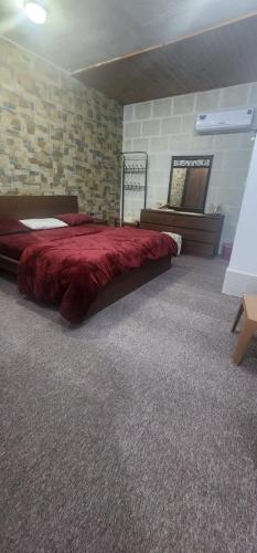 a bedroom with a large bed with a red blanket at الاردن - جرش in Jerash