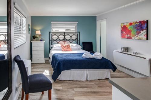 a bedroom with a bed with a blue wall at May-Dee Suites in Florida in Hollywood