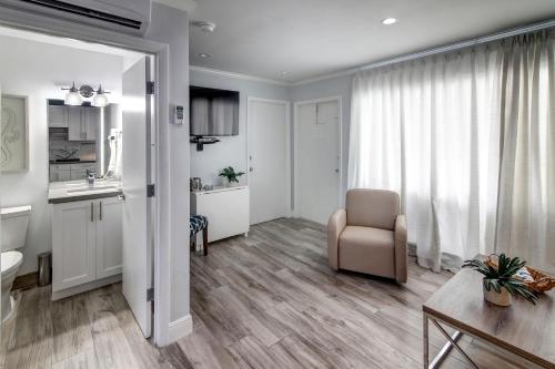 ein großes Wohnzimmer mit einem Stuhl und einer Küche in der Unterkunft May-Dee Suites in Florida in Hollywood