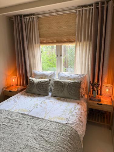 a bedroom with a bed with pillows and a window at Knus Tiny house 2 pers rust natuur en privacy in Borger