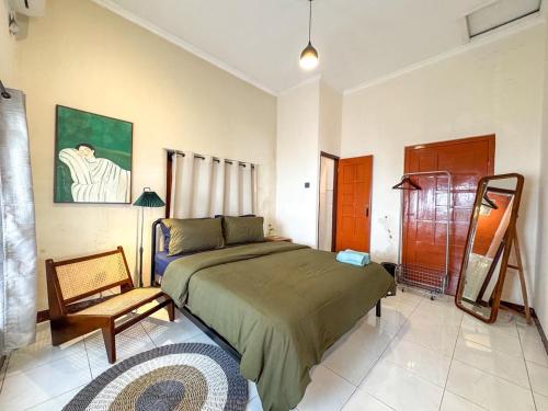 a bedroom with a bed and a chair in it at ŚamaStay in Yogyakarta