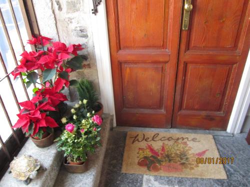 a door with flowers and a welcome mat in front of it at Casa Amata in Lecco