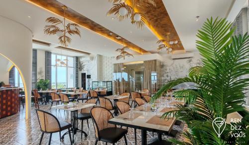 a restaurant with tables and chairs and plants at Radiant Hotel and Events in San Fernando