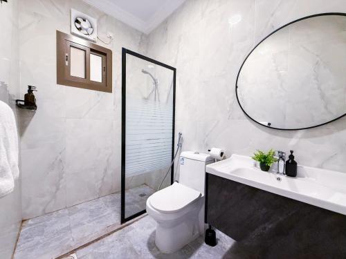 a bathroom with a toilet and a sink and a mirror at HOMETEL An Nahdah in Jeddah