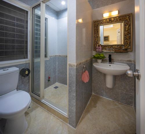 a bathroom with a shower and a toilet and a sink at Pink Horizon Saigon Airport Hotel in Ho Chi Minh City