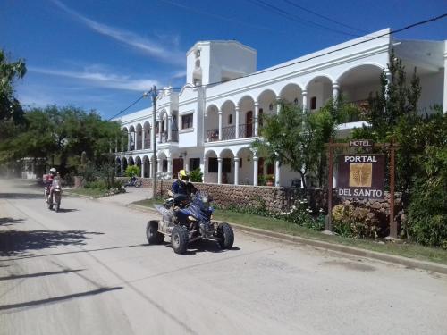 a man riding a quad bike down a street in front of a building at Hotel Portal del Santo in Cafayate