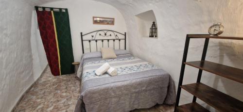 a small bedroom with a bed in a room at Casa Cueva Calatrava in Tabernas