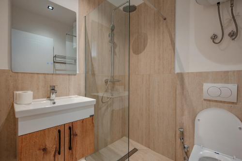 a bathroom with a sink and a glass shower at Queen Residence & Hotel in Shëngjin