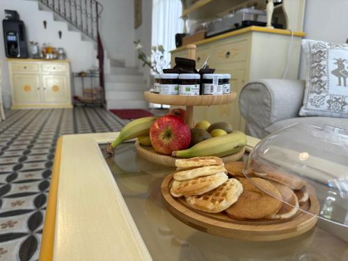 a table with a plate of bread and fruit on it at NG Guest House Ammentos in Olbia