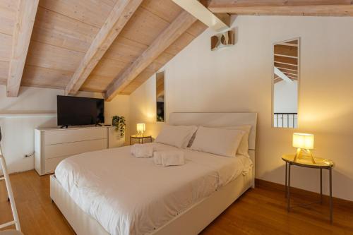 a bedroom with a white bed and a television at Yourbanflat Ring River in Padova