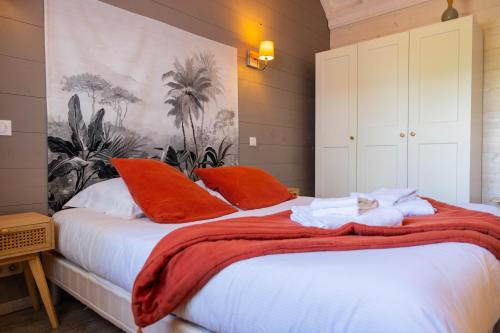 a bedroom with a bed with orange pillows at Gite de Mortagne, Villa avec Piscine in Gigny-sur-Saône