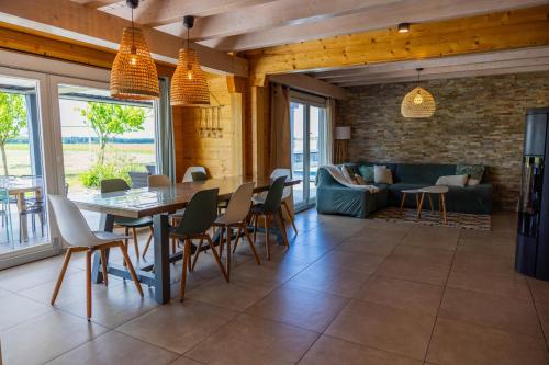 a dining room with a table and chairs and a couch at Gite de Mortagne, Villa avec Piscine in Gigny-sur-Saône
