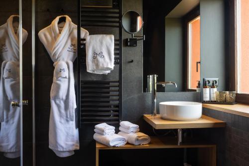 a bathroom with towels hanging on a wall and a sink at La Villa du Morakopf - Colmar in Niedermorschwihr