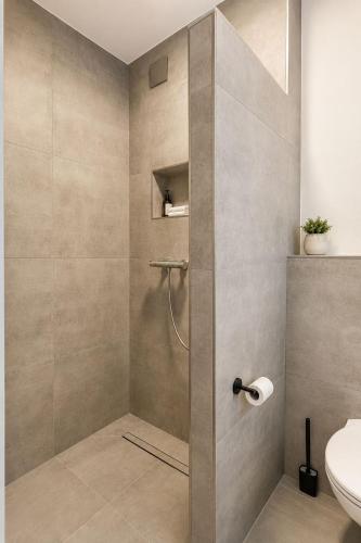 a bathroom with a shower with a toilet at StayIN Suites in Griesheim