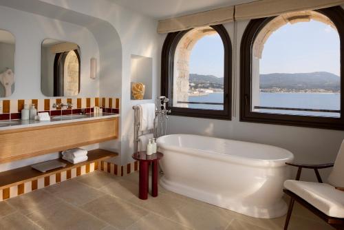 a bathroom with a large tub and two windows at Zannier Île de Bendor in Bandol
